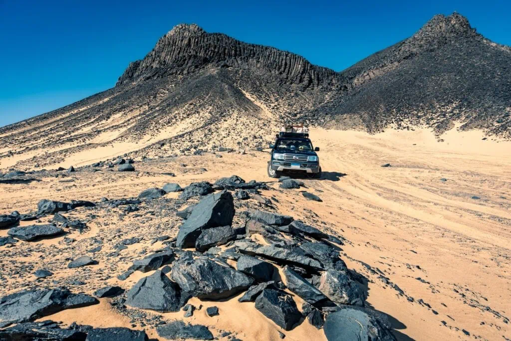 Dark basalt-covered hill rising from the desert plain, The Assembled Mountain, Bahariya Oasis