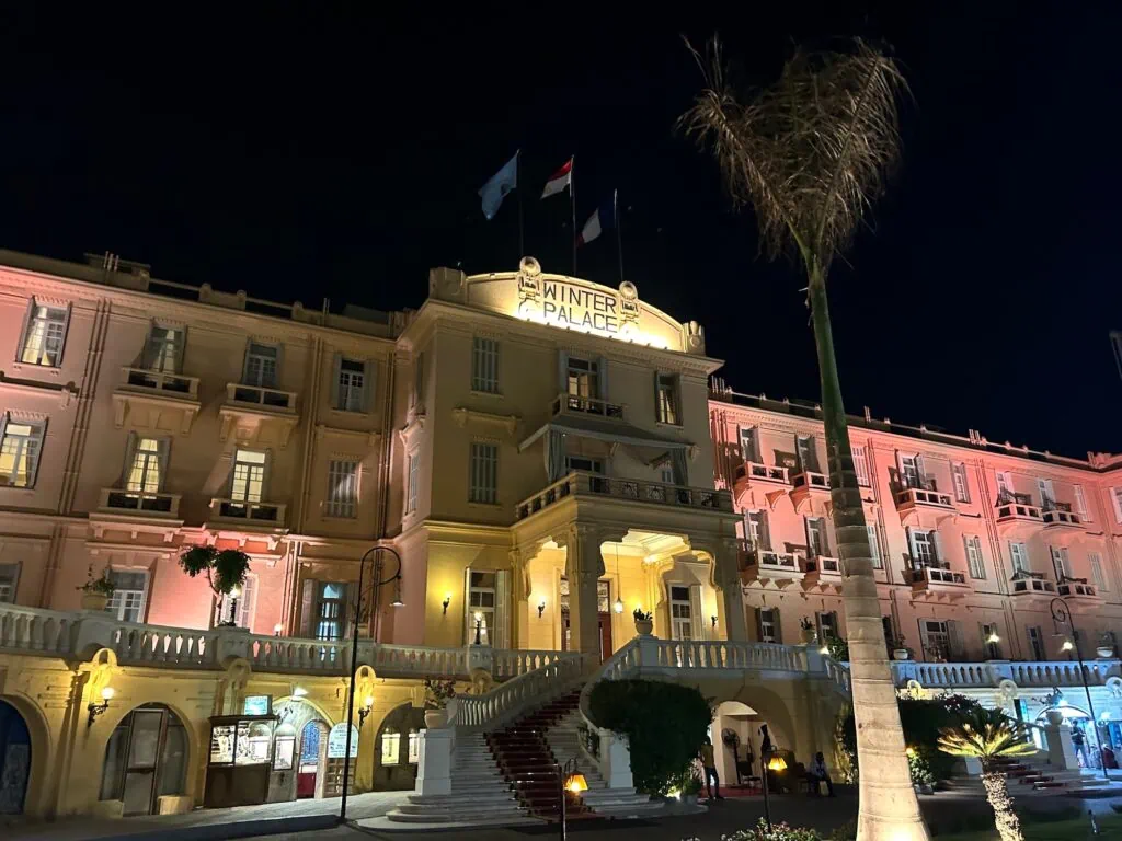 The Sofitel Winter Palace hotel in Luxor illuminated at night, a historic Nile-side property combining period character with modern accessibility, requestable as an upgrade on a private Egypt tour for seniors.