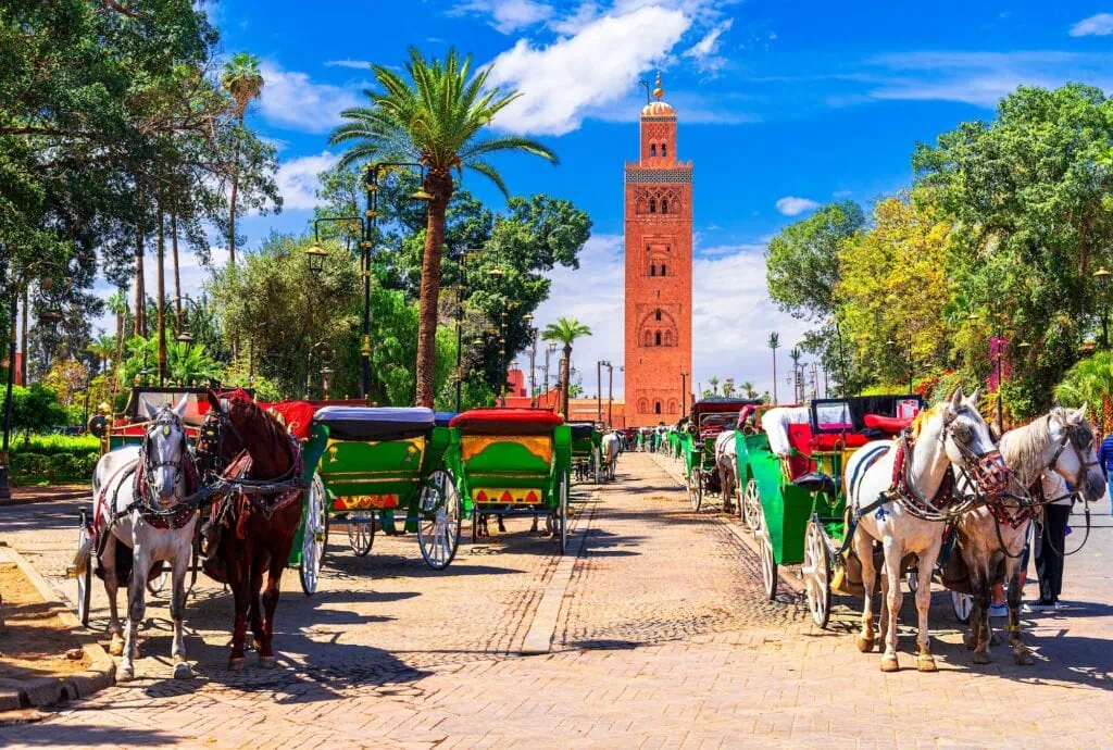 Koutoubia Mosque minaret rising over Jemaa el-Fnaa square in Marrakech, the 12th-century Almohad landmark and tallest structure in the medina at 77 metres.
