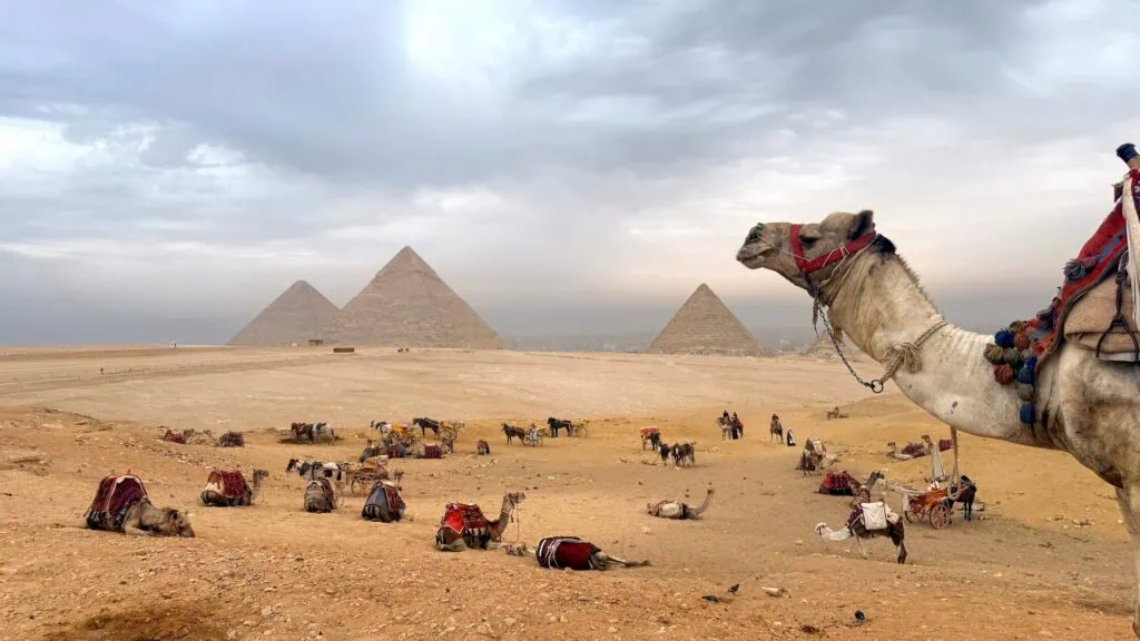 The three Pyramids of Giza — Khufu, Khafre, and Menkaure — aligned across the western desert plateau outside Cairo, the only surviving Wonder of the Ancient World, the Cairo opening on every Luxury Egypt Tours itinerary.
