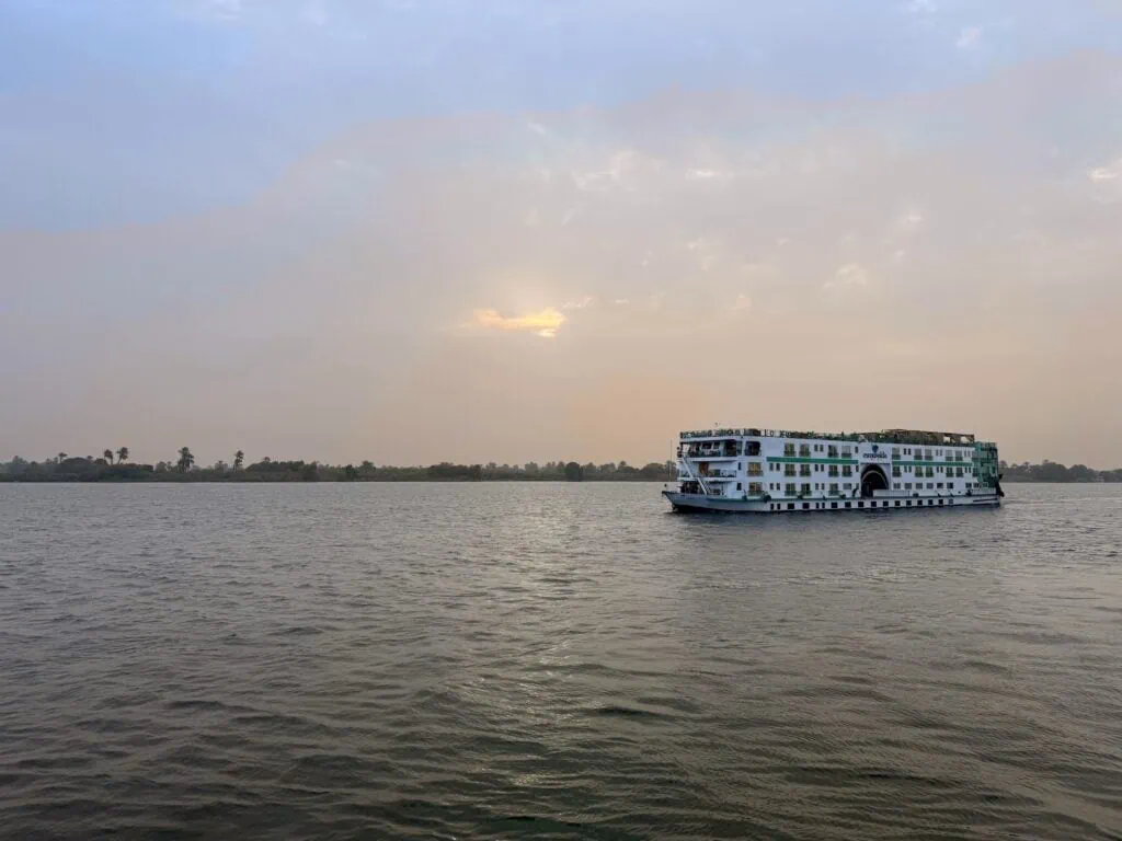 Nile cruise ship sailing along the river with desert banks in Aswan