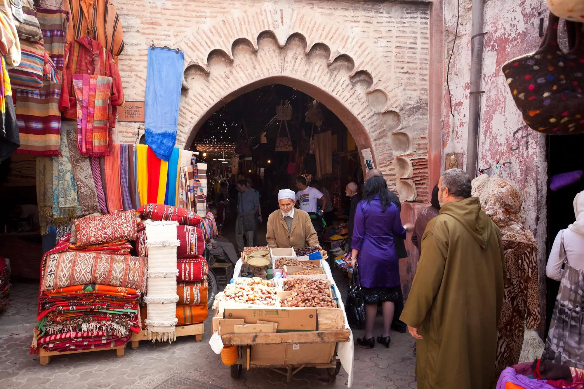 Busy traditional souk marketplace in Marrakech with vendors and shoppers