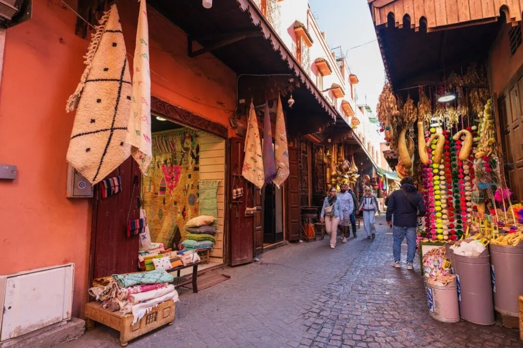 Marrakesh souk street with narrow alleys lined by shops displaying textiles, crafts, and goods Marrakech
