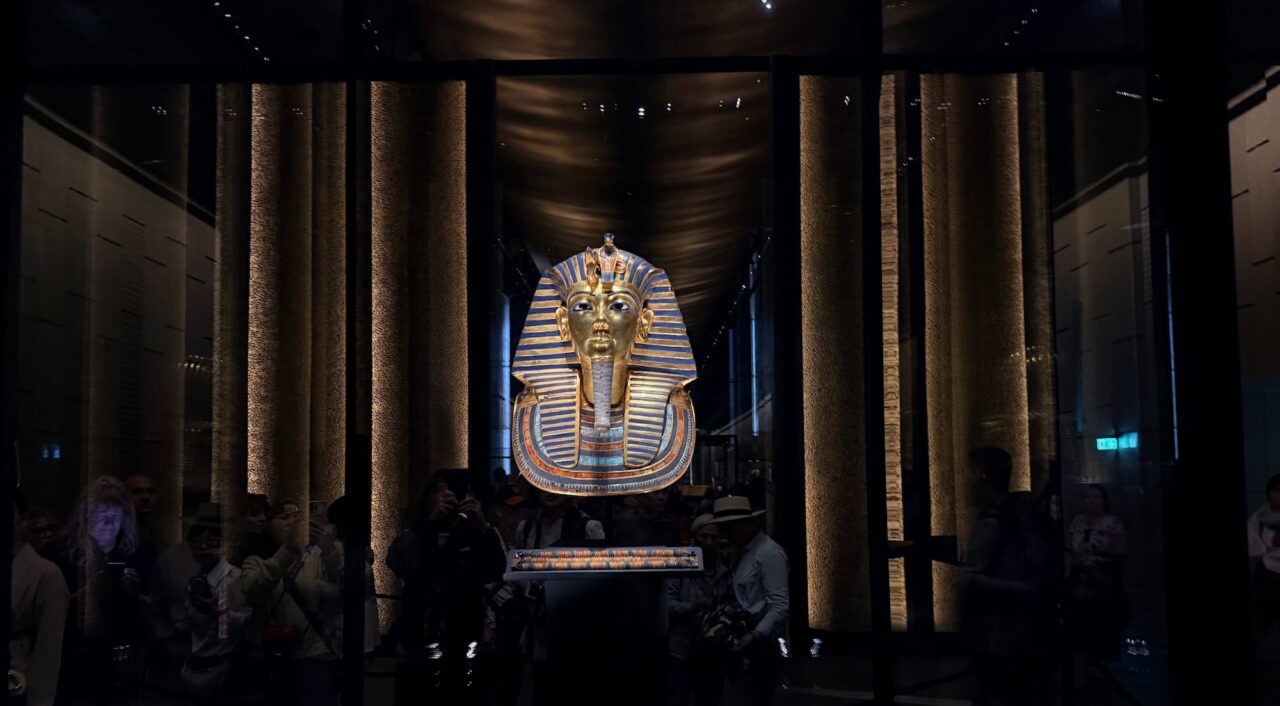 A close-up view of the golden funerary mask of King Tutankhamun, one of the most iconic treasures of ancient Egypt, displayed inside the Grand Egyptian Museum in Giza