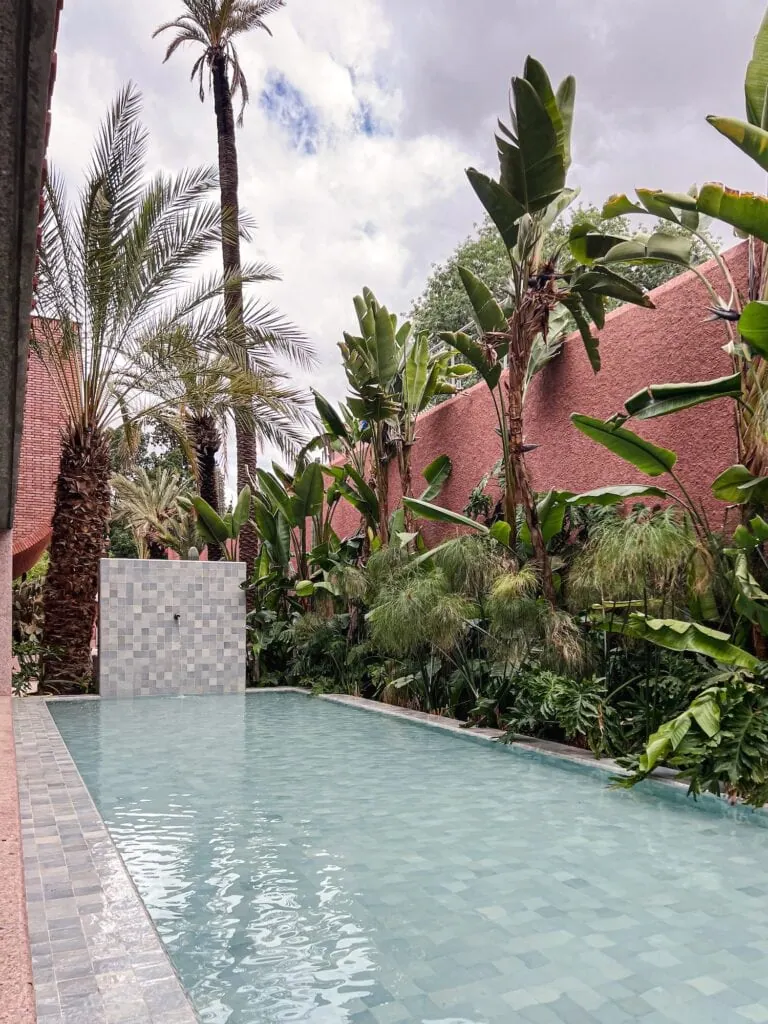 Yves Saint Laurent Museum water garden with rectangular basin surrounded by plants and terracotta walls Marrakech