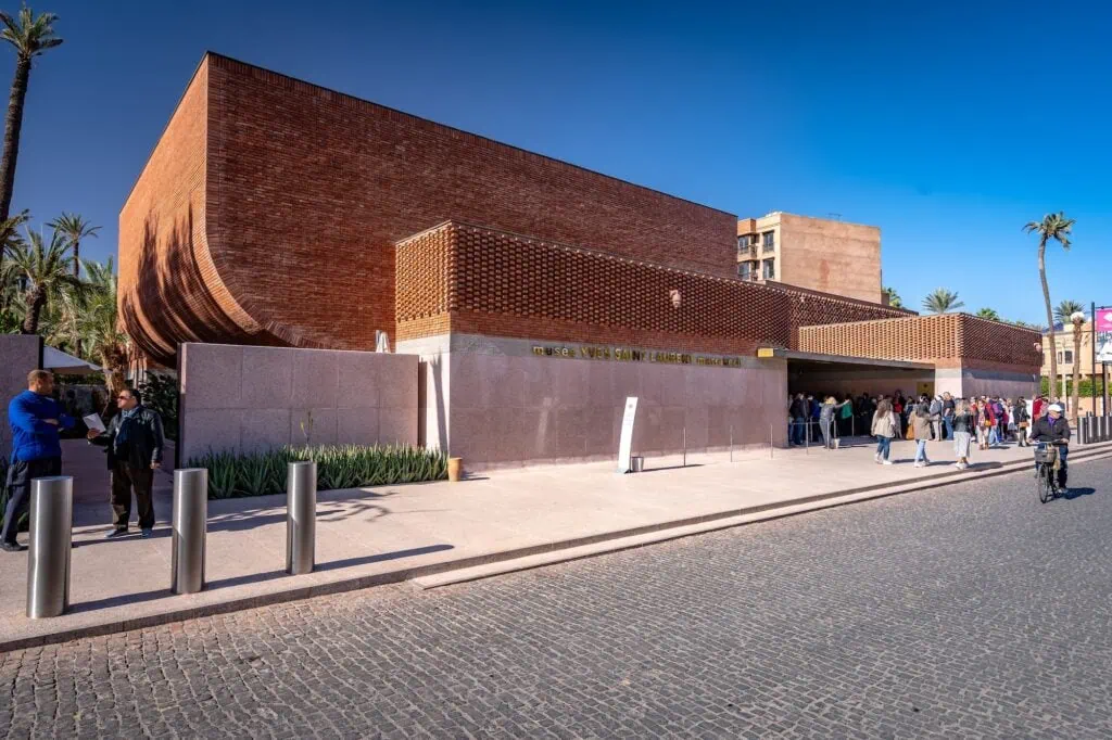 Yves Saint Laurent Museum exterior with curved terracotta facade and minimal entrance set within landscaped grounds Marrakech